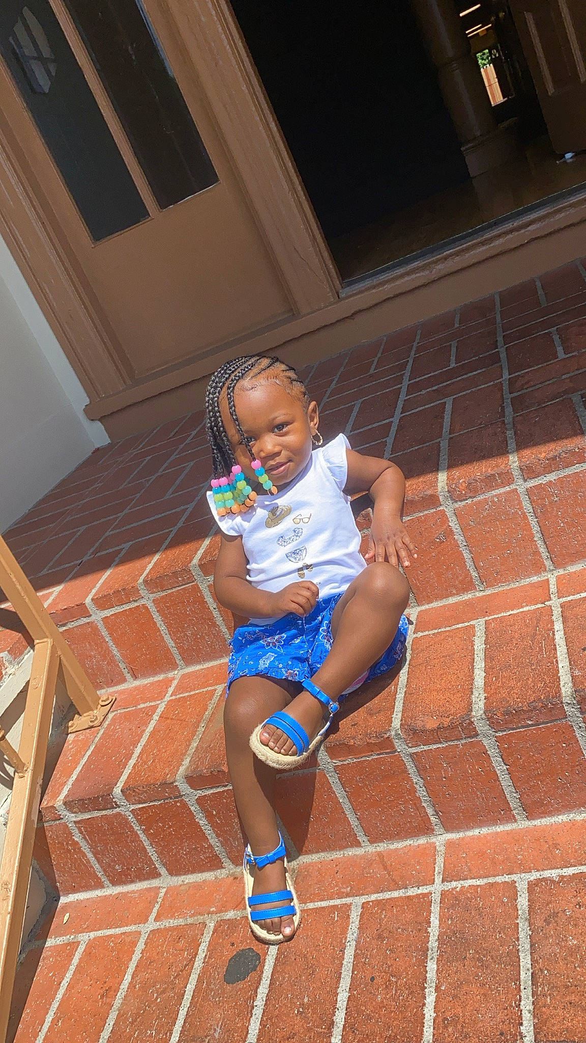 Taylor is registered to the contest to win money with this photo: baby_toddler_clothing, child, electric_blue, floor, flooring, foot, fun, human_leg, knee, leg, leisure, pattern, person, sandal, shorts, sidewalk, sitting, sunglasses, thigh, toddler