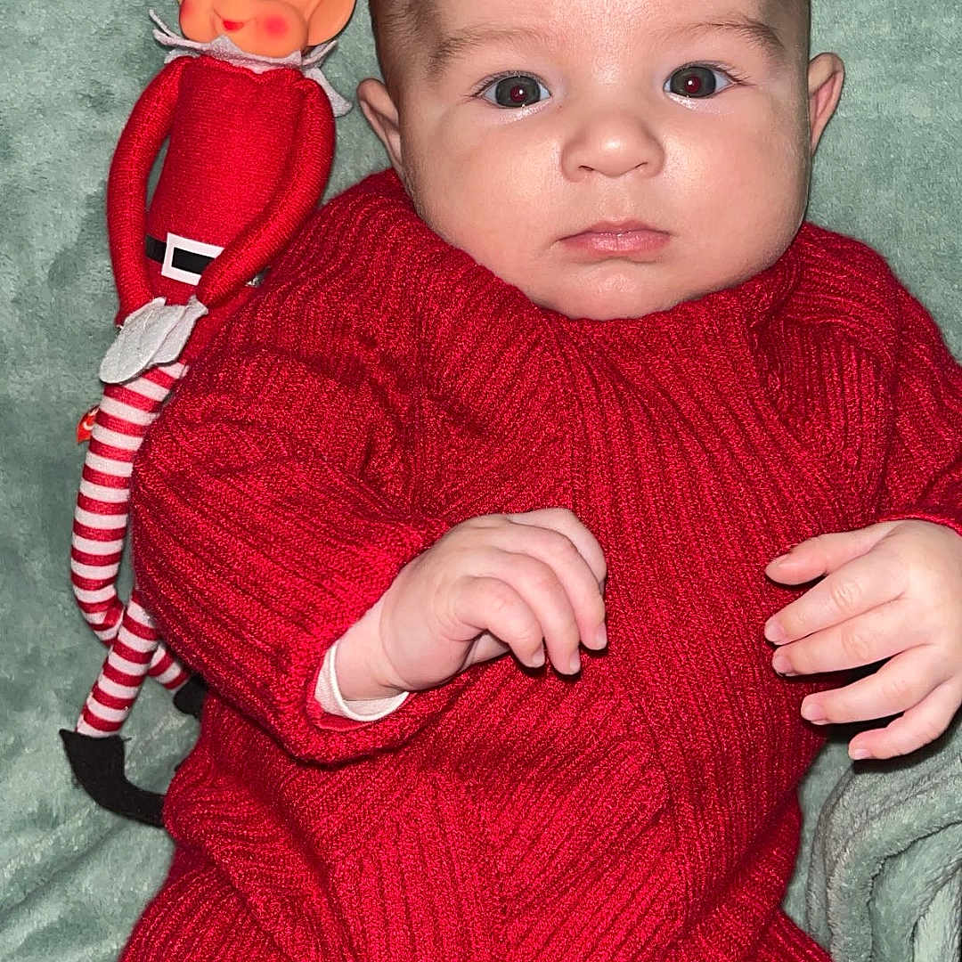 Mattéo participe au concours pour gagner de l'argent avec cette photo : baby, bodypart, clothing, costume, couch, doll, face, finger, furniture, hand, happy, hat, head, knitwear, person, photography, portrait, smile, sweater, toy