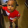 Legend joined the competition — help win amazing prizes! toddler, child, indoor, floor, red_shirt, nike, sneakers, black_hair, pigtails, curious, looking_up, standing, cute, young_child, person, footwear, clothing, expression, portrait, baby