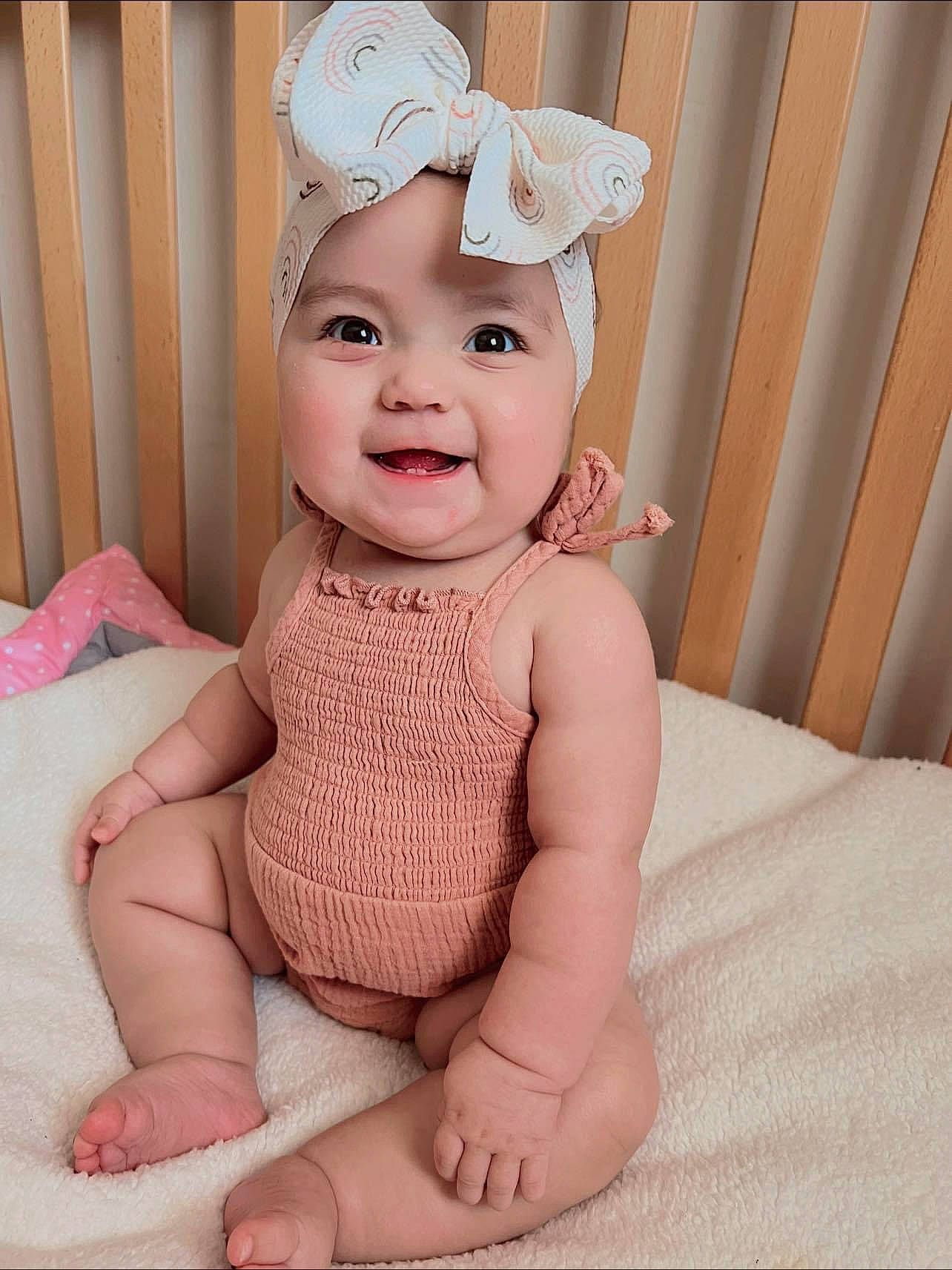 Bethany joined the competition — help win amazing prizes! baby, baby_toddler_clothing, cap, child, comfort, eye, fashion_accessory, finger, happy, head, headband, headwear, human_leg, iris, joy, pattern, person, pink, sitting, skin