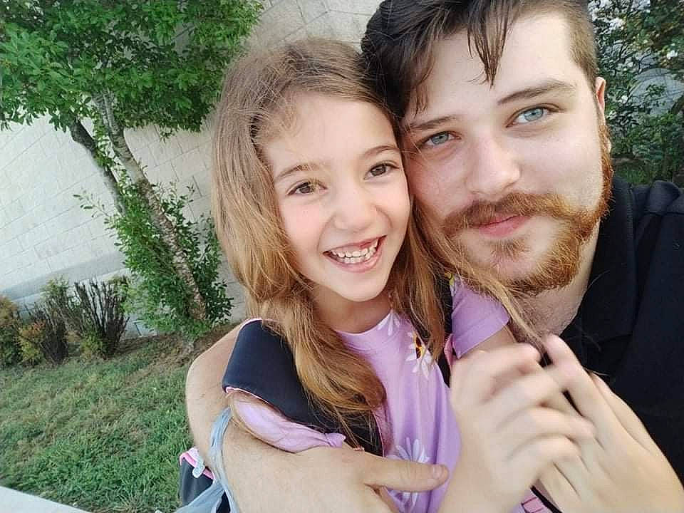 Elle is registered to the contest to win money with this photo: beard, child, event, eye, fun, gesture, grass, happy, iris, joy, leisure, lip, nose, people_in_nature, person, plant, recreation, skin, smile, thumb