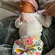 Emma joined the competition — help win amazing prizes! baby, infant, blanket, headband, floral_pants, white_socks, hand, person, sleeping, resting, soft_texture, indoor, cute, newborn, comfort, tenderness, clothing, portrait, lying_down, peaceful