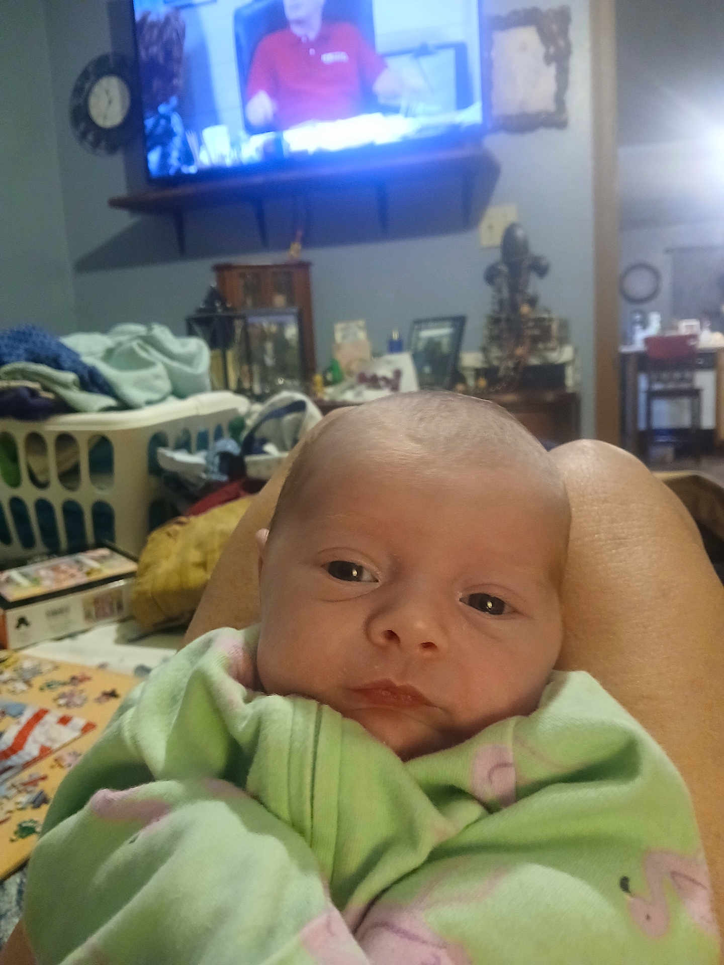 Rosa'Lli Benoit joined the competition — help win amazing prizes! baby, infant, blanket, legs, living_room, laundry_basket, television, furniture, person, clothing, home_interior, blanket_pattern, pink, green, face, eyes, table, decor, couch, relaxing