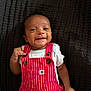 Dominic joined the competition — help win amazing prizes! baby, infant, smiling, red_overall, striped_clothing, white_shirt, lying_down, quilted_blanket, dark_background, cute, happy, child, portrait, button_details, small_hand, face, young, one_person, indoors, casual_clothing