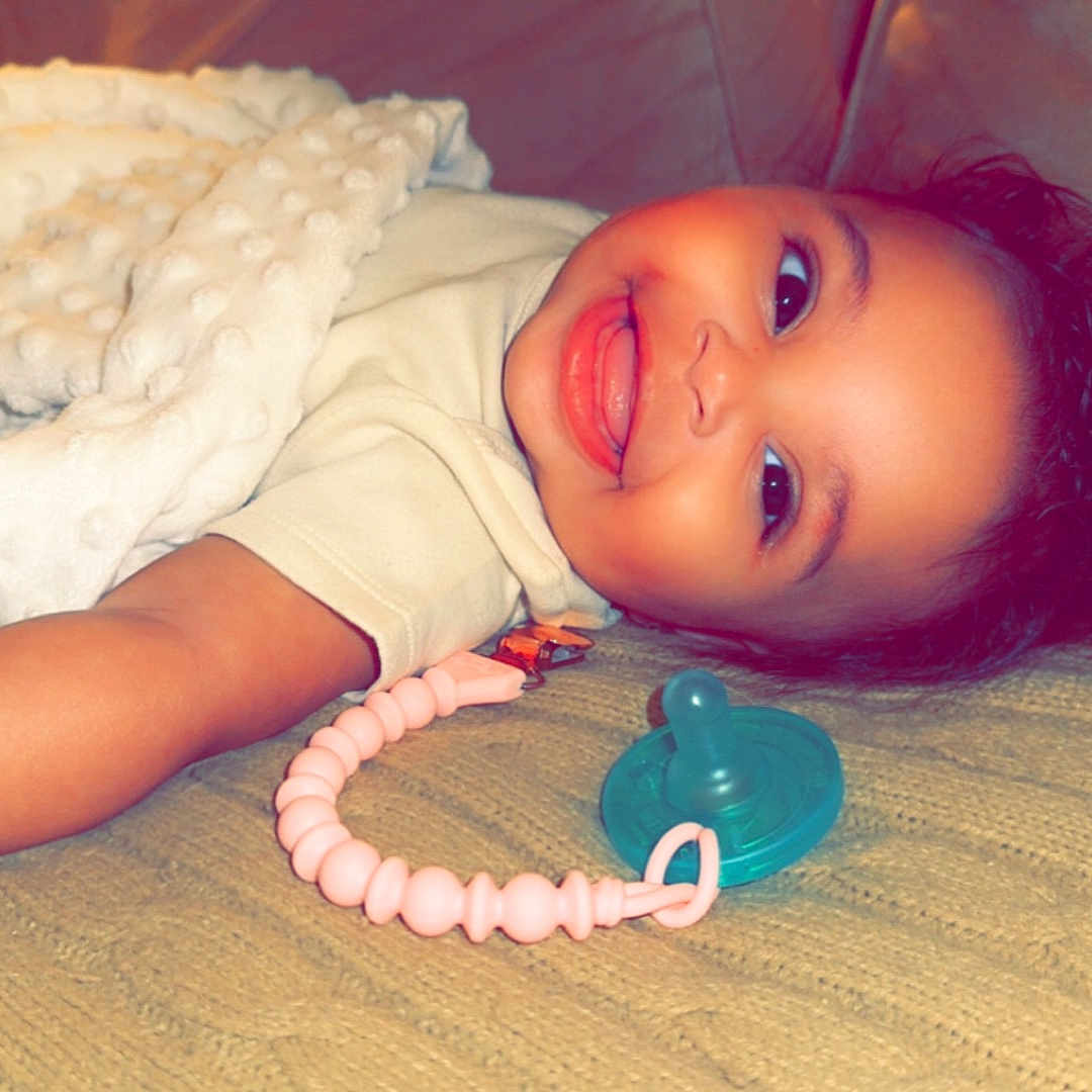 Naomi is registered to the contest to win money with this photo: accessories, baby, bodypart, bracelet, couch, face, finger, furniture, hand, happy, head, homedecor, jewelry, mouth, necklace, person, photography, portrait, smile, toy