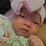 Ashly is registered to the contest to win money with this photo: adorable, baby, baby_clothing, child, close_up, cozy, cuddling, eyes, face, fist, floral_clothing, hands, headband, holding, indoor, infant, newborn, onesie, pink_bow, portrait