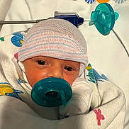 Michael is registered to the contest to win money with this photo: newborn, baby, pacifier, hat, blanket, hospital, infant, closeup, wrapped, bed, child, face, patterned_blanket, sleepwear, lying_down, cute, tiny, soft, hospital_bed, swaddled