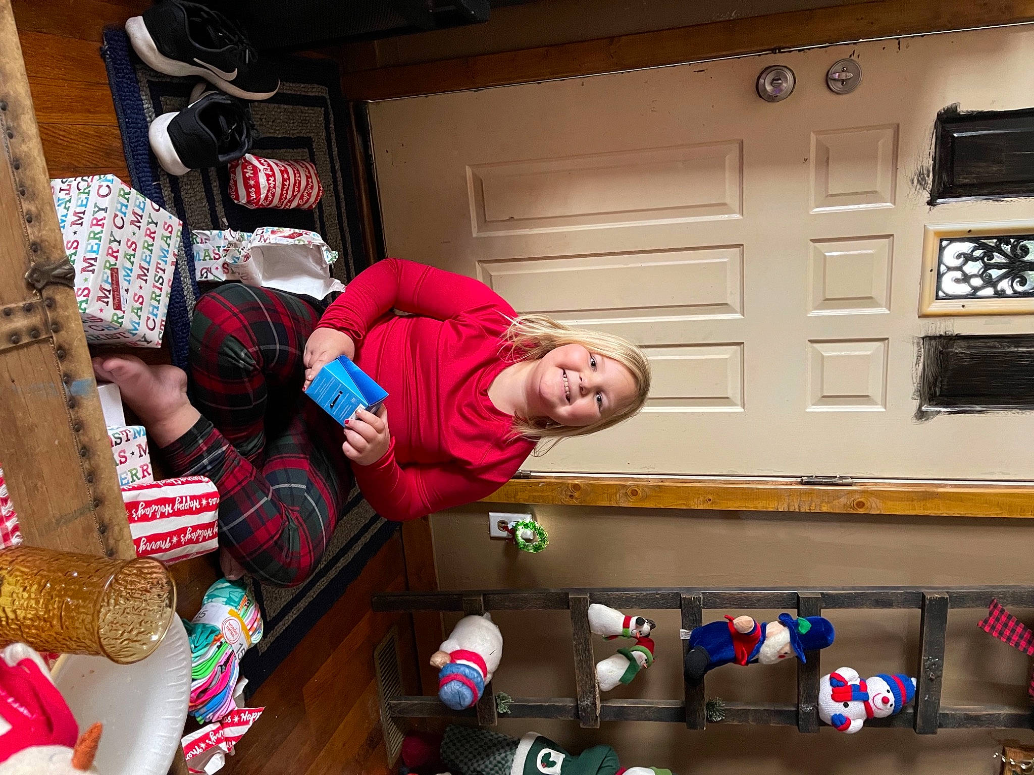 Brooklynn is registered to the contest to win money with this photo: box, cabinetry, joy, living_room, person, present, stuffed_toy