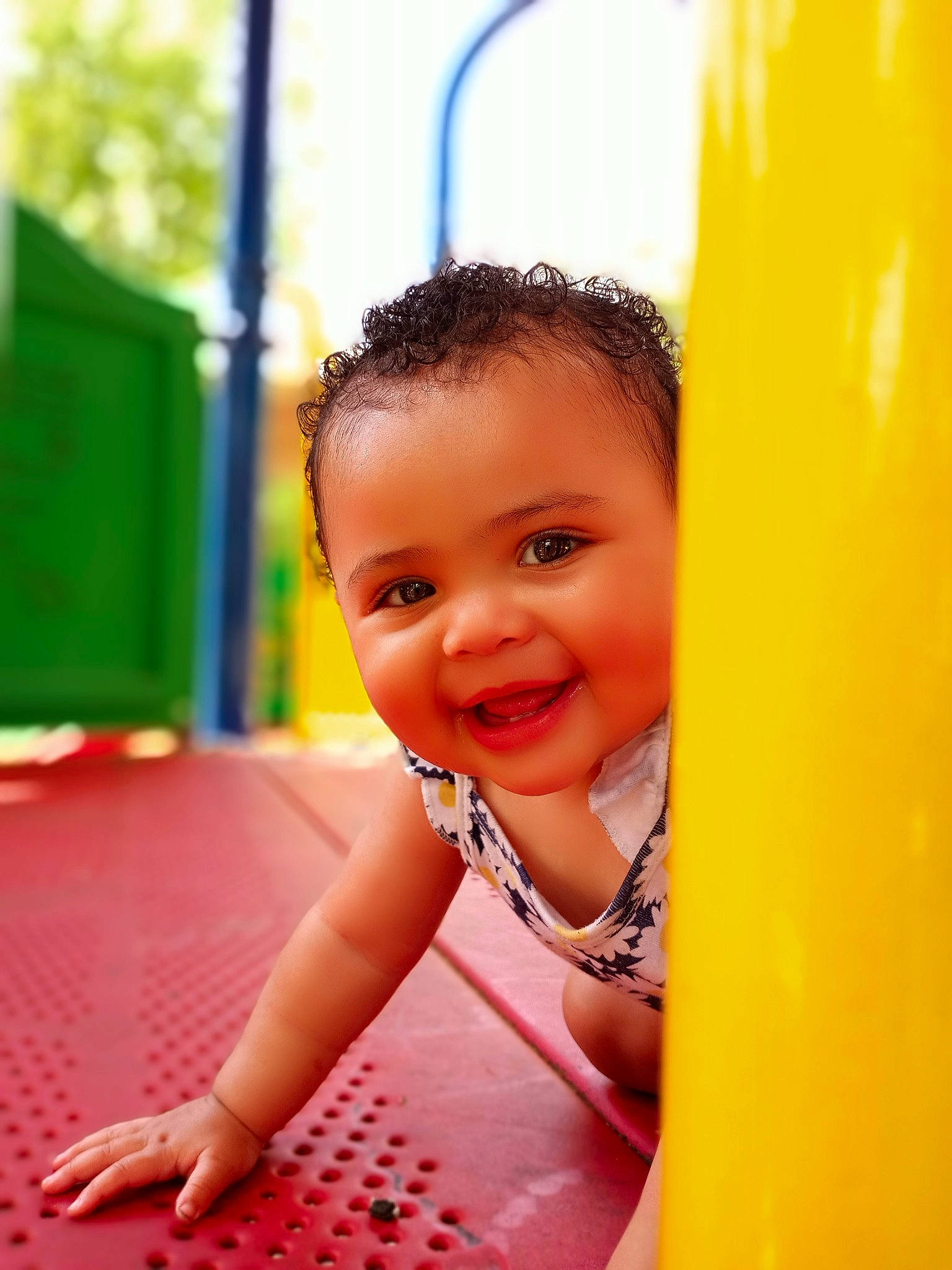 Jalina is registered to the contest to win money with this photo: baby, child, chute, close_up, facial_expression, fun, grass, green, happy, joy, leisure, nose, outdoor_play_equipment, person, playground, playground_slide, recreation, skin, smile, summer