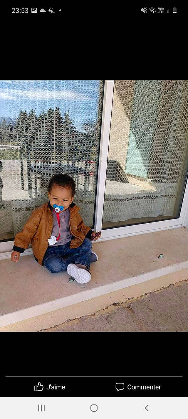 Ilario a rejoint le concours — aidez-le/la à gagner de superbes lots ! baby, baby_toddler_clothing, building, child, city, denim, flooring, jacket, leisure, person, room, sitting, sleeve, sneakers, standing, tints_and_shades, toddler, window, window_covering, window_treatment