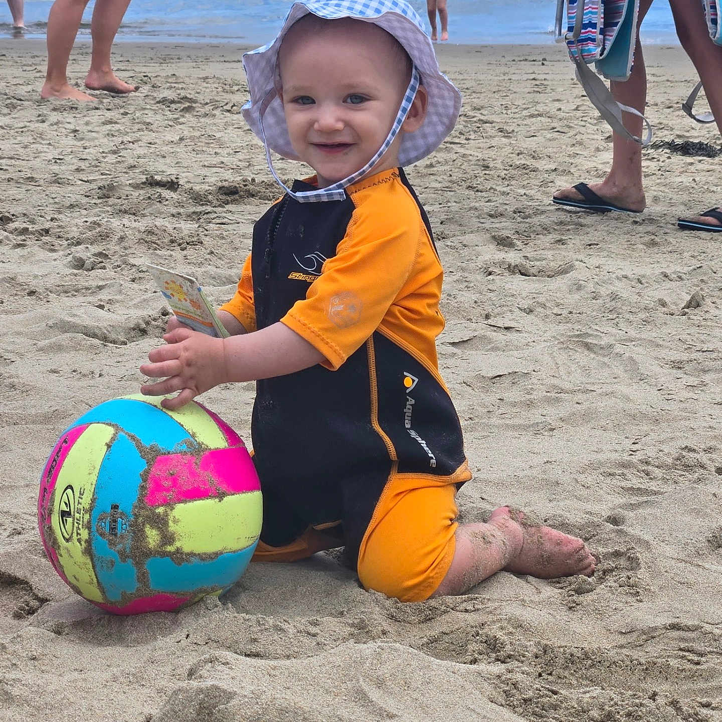 Jerico joined the competition — help win amazing prizes! beach, child, family, fun, happy, legs, ocean, orange_wetsuit, outdoor, people, playing, sand, smiling, summer, sun_hat, swimsuit, toddler, vacation, volleyball, water