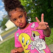 Ivionna joined the competition — help win amazing prizes! child, girl, curly_hair, pink_tshirt, tweety_bird, outdoor, greenery, sunny, pavement, playful, pout, hand_gesture, summer, casual_clothing, nature, portrait, young, happy, daylight, fun