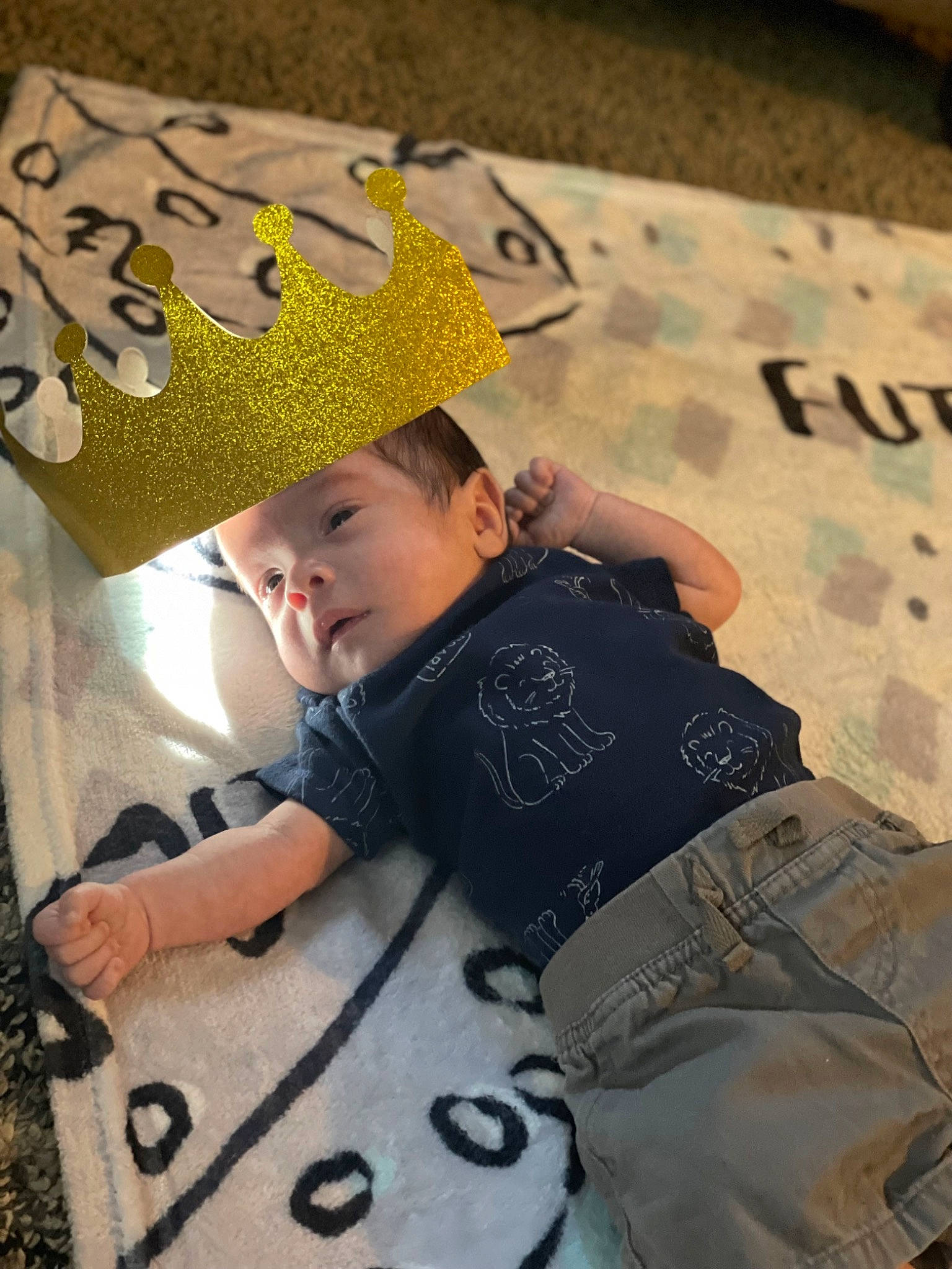 Clark is registered to the contest to win money with this photo: baby, bag, cap, child, clothing, cool, fashion_accessory, flooring, font, fun, happy, hat, headgear, headwear, outerwear, pattern, person, sitting, t_shirt, textile
