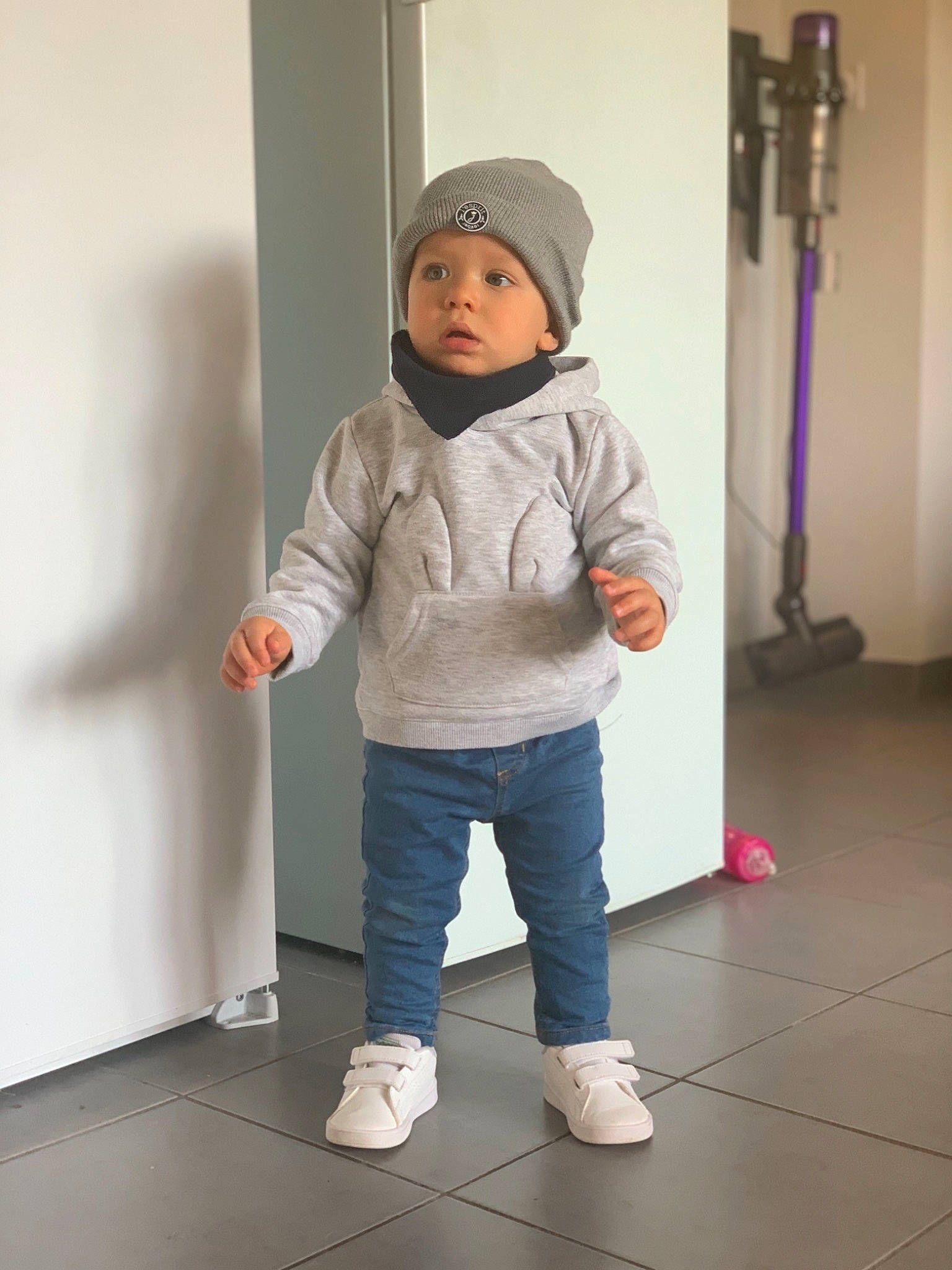 Camille participe au concours pour gagner de l'argent avec cette photo : baby, baby_toddler_clothing, child, cleanliness, floor, flooring, foot, fun, hardwood, headwear, hood, hoodie, human_leg, jacket, knee, person, room, sleeve, toddler, wood