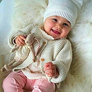 Sealy Santos López is registered to the contest to win money with this photo: baby, child, smiling, knit_hat, knit_sweater, pink_pants, toy, stuffed_animal, soft_texture, fluffy_blanket, indoor, cute, portrait, happy, infant, warm_clothing, cozy, sitting, playful, toddler