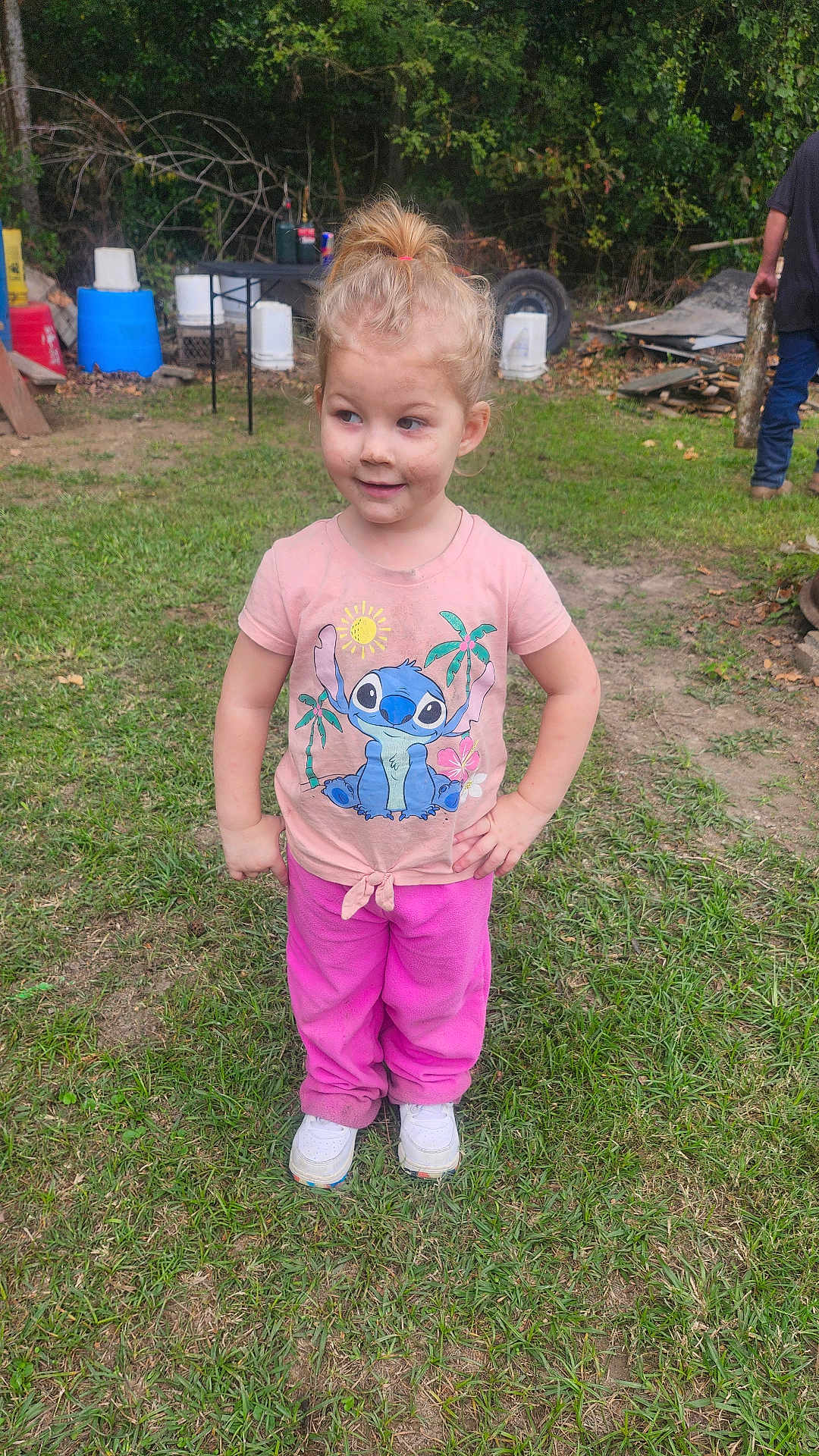 Logan joined the competition — help win amazing prizes! child, girl, outdoor, grass, pink_clothing, white_shoes, playful, standing, messy_face, casual, backyard, trees, person, stitch_tshirt, pants, smiling, hands_on_hips, dirt, daylight, man
