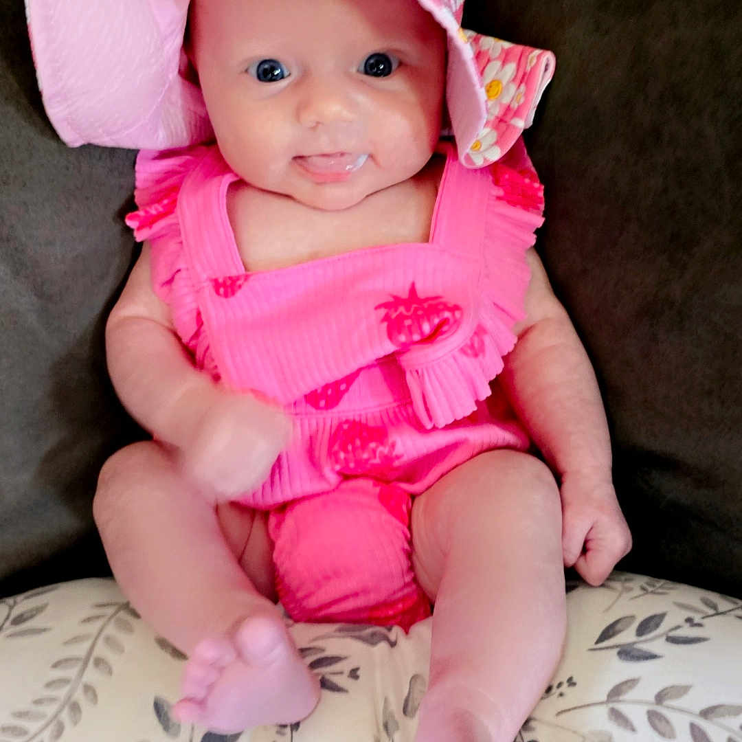 Mykenna joined the competition — help win amazing prizes! baby, bodypart, bonnet, cap, clothing, costume, couch, cushion, dress, face, furniture, hat, head, homedecor, newborn, person, photography, portrait, sitting, sunhat