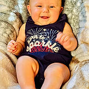 Lauren joined the competition — help win amazing prizes! baby, infant, smiling, onesie, clothing, fireworks, blanket, soft, cute, happy, chubby_cheeks, face, skin, person, portrait, sitting, cozy, indoor, child, newborn