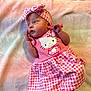 Izabella is registered to the contest to win money with this photo: baby, infant, pink, headband, hello_kitty, dress, blanket, soft_texture, cute, child, newborn, laying_down, clothing, portrait, small_hands, foot, gaze, indoors, comfort, youth