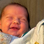 Izabella joined the competition — help win amazing prizes! baby, smile, blanket, closeup, face, infant, sleepy, cozy, child, cute, wrapped, soft, newborn, happy, portrait, peaceful, indoors, skin, expression, babywear