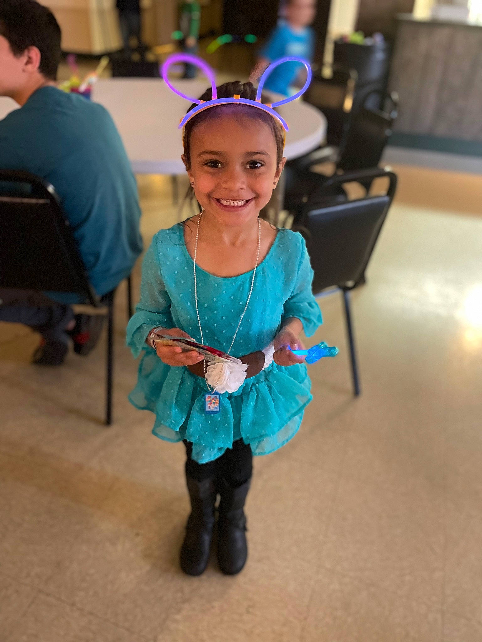 Emma is registered to the contest to win money with this photo: chair, child, electric_blue, entertainment, event, fashion_design, flooring, formal_wear, fun, hair, hairstyle, happy, head, jewellery, joy, leisure, party, person, recreation, smile