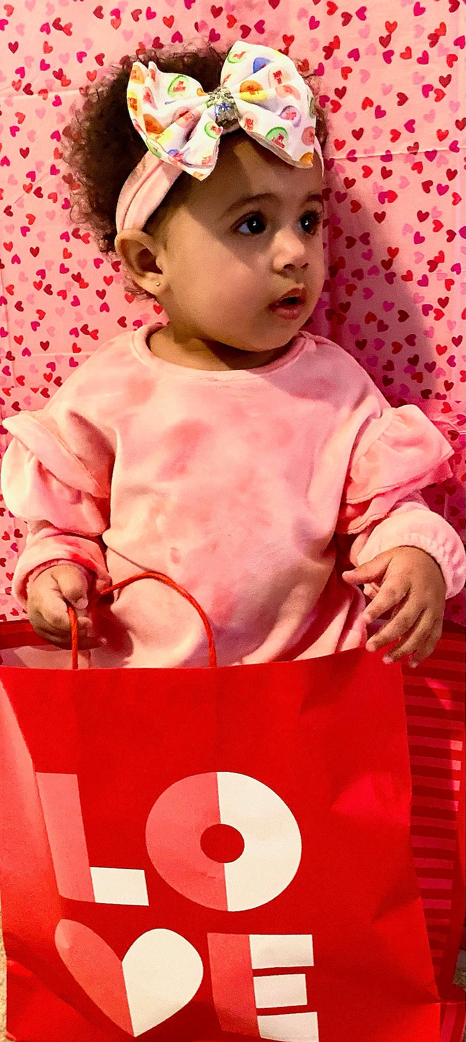 Londyn is registered to the contest to win money with this photo: baby, baby_toddler_clothing, cap, cheek, dress, event, facial_expression, happy, hat, headwear, human_body, magenta, pattern, peach, person, pink, red, skin, sleeve, standing