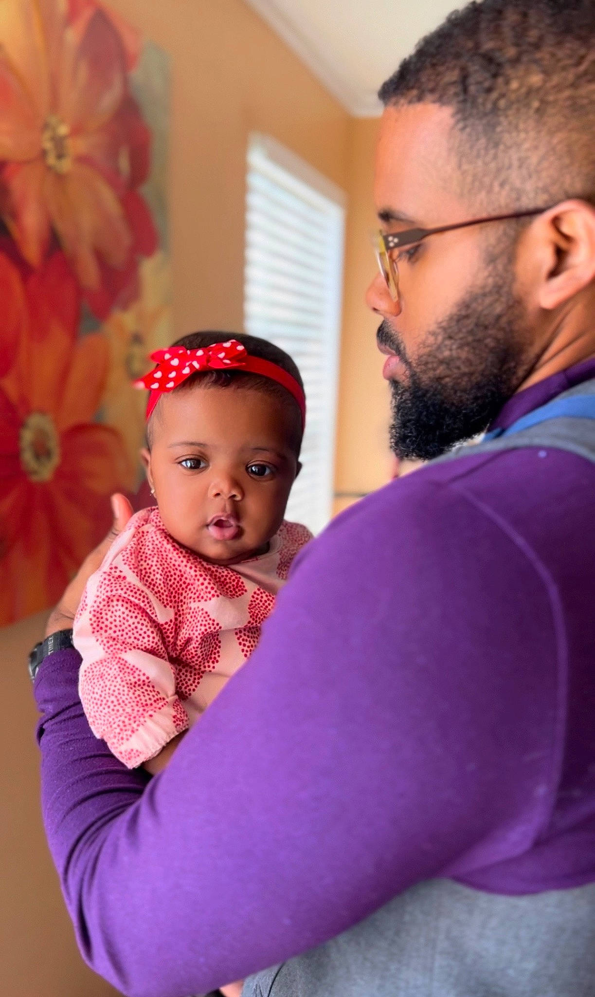 Cori is registered to the contest to win money with this photo: baby, baby_toddler_clothing, beard, child, event, eyewear, face, flower, fun, gesture, glasses, happy, head, interaction, magenta, person, pink, purple, skin, toddler