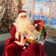 Arthur a rejoint le concours — aidez-le/la à gagner de superbes lots ! santa_claus, baby, child, christmas, holiday, festive, costume, beard, red_clothing, chair, indoor, decorations, tree, winter, window, curtain, glasses, smiling, person, seasonal
