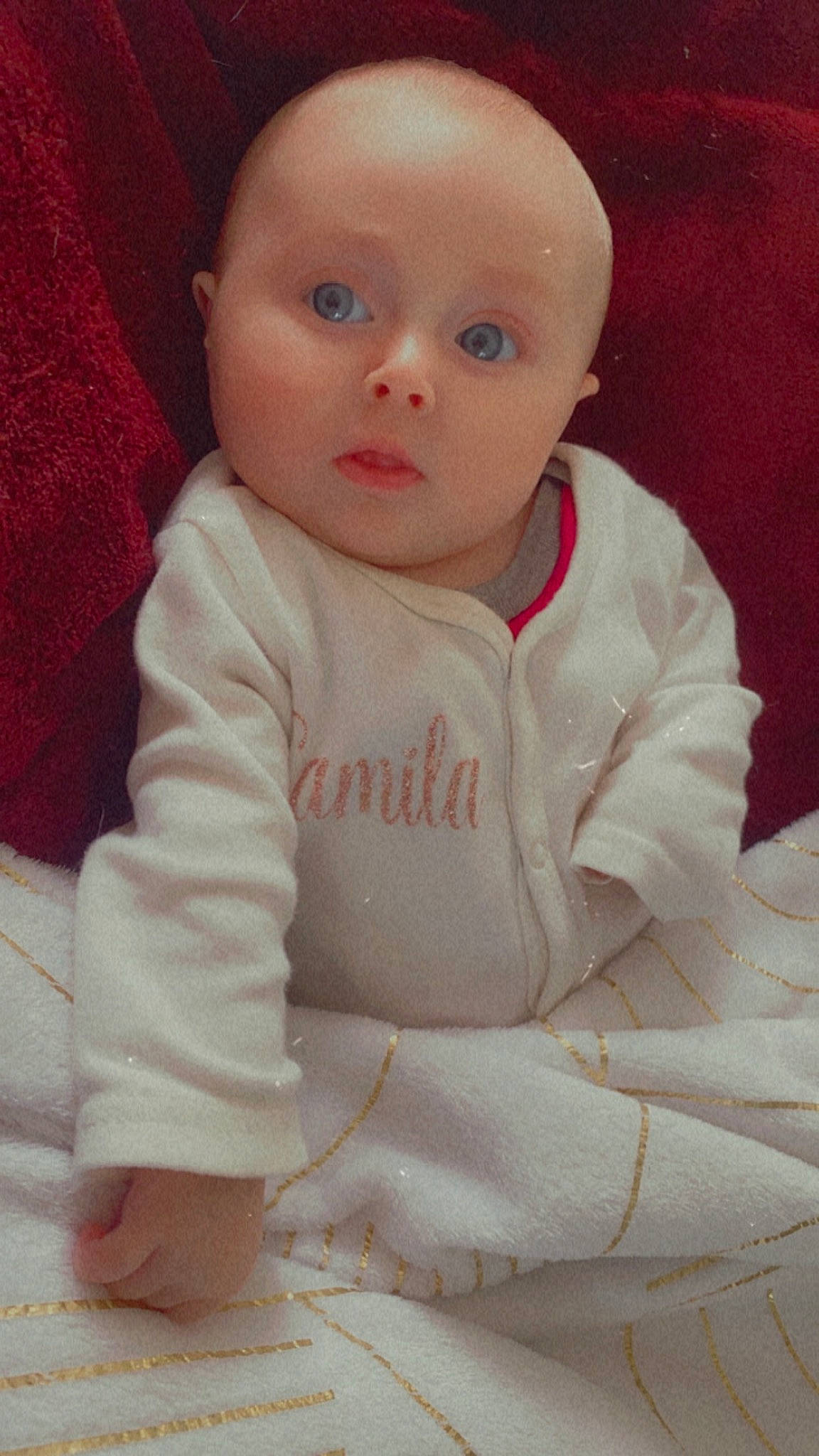Camila participe au concours pour gagner de l'argent avec cette photo : arm, baby, baby_toddler_clothing, carmine, cheek, child, chin, comfort, face, flooring, fur, head, linens, lip, no_expression, nose, person, skin, sleeve, surprise