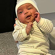 Justin joined the competition — help win amazing prizes! baby, carpet, child, cozy, cute, face, floor, hands, hat, home, indoor, infant, person, playful, pom_pom, portrait, smiling, striped_clothing, warm_clothing, young