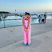 Lilyana joined the competition — help win amazing prizes! child, girl, pink_outfit, playful_pose, smiling, marina, waterfront, lighthouse, boats, yacht, sailboat, harbor, dock, seaside, outdoor, sunset, travel, portrait, fashion, blue_shoes