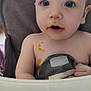 baby, child, blue_eyes, high_chair, food_stains, curious, indoor, face, skin, person, table, hair, expression, closeup, seat, messy, cute, infant, portrait, sitting
