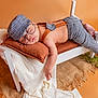 Nathan is registered to the contest to win money with this photo: baby, blanket, cap, clothing, cushion, glove, hat, homedecor, infantbed, person, shorts, sleeping, spa, sunbathing
