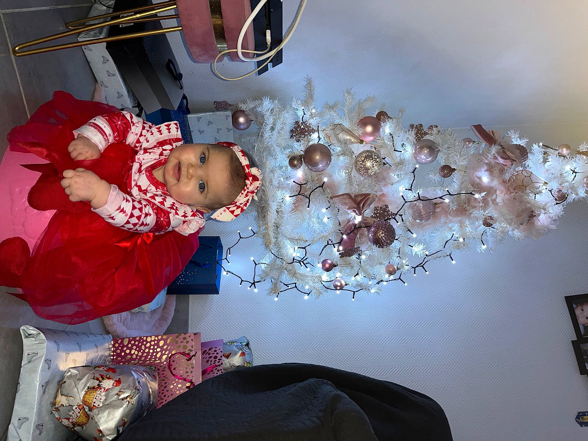 Aria participe au concours pour gagner de l'argent avec cette photo : baby, baby_toddler_clothing, carmine, child, christmas, christmas_decoration, christmas_eve, event, fun, happy, holiday, interior_design, ornament, person, room, smile, textile, toddler, tree, window