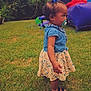 bounce_house, child, curly_hair, daytime, denim, dress, floral_pattern, fun, girl, grass, greenery, hair_bow, nature, outdoor, pacifier, playground, sandals, side_view, summer, toddler