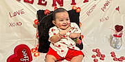 Leandro C is registered to the contest to win money with this photo: baby, infant, child, smile, valentine_banner, hearts, heart_decor, rose, kiss_marks, fairy_lights, red_shorts, heart_shirt, sitting, pillow, vase, chocolates, decorations, white_backdrop, photography, cute