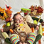 Leandro C is registered to the contest to win money with this photo: baby, infant, smiling, milestone_sticker, onesie, striped_leggings, carrots, zucchini, corn, sunflower, autumn_decor, fall_leaves, aluminum_tray, thanksgiving, cozy, portrait, plush_pillow, tablecloth, vegetables, edible_props