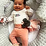 Alya participe au concours pour gagner de l'argent avec cette photo : baby, infant, smiling, clothing, plush_toy, rattle, baby_nest, soft_texture, pink_pants, white_shirt, cute, happy, lying_down, cozy, child, head, face, sock, indoor, newborn