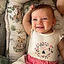 baby, smiling, infant, cushion, blanket, baby_nest, animal_print, giraffe, tiger, pink_clothing, white_top, floral_pattern, happy, cute, portrait, child, indoors, soft_texture, comfort, resting