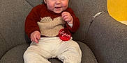 Lyson participe au concours pour gagner de l'argent avec cette photo : baby, child, smiling, sitting, sweater, pants, sock, chair, cushion, ornament, red, gray, cozy, cute, indoor, portrait, happy, face, hand, furniture