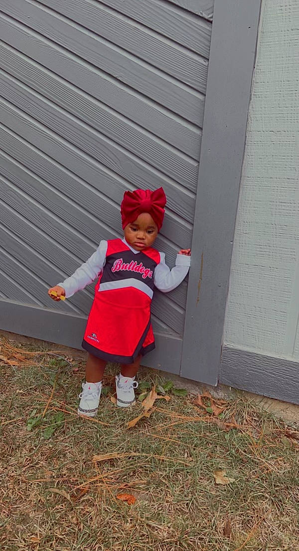 Madilyn is registered to the contest to win money with this photo: baby_toddler_clothing, cap, carmine, child, door, fun, grass, hat, headwear, magenta, people_in_nature, person, siding, soil, tints_and_shades, toddler