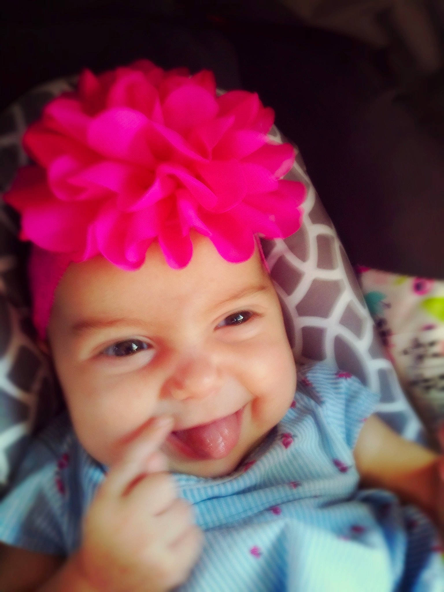 Eden is registered to the contest to win money with this photo: baby, cheek, child, ear, face, facial_expression, fashion_accessory, forehead, fun, hair_accessory, head, headgear, headwear, lip, mouth, nose, person, pink, plant, skin