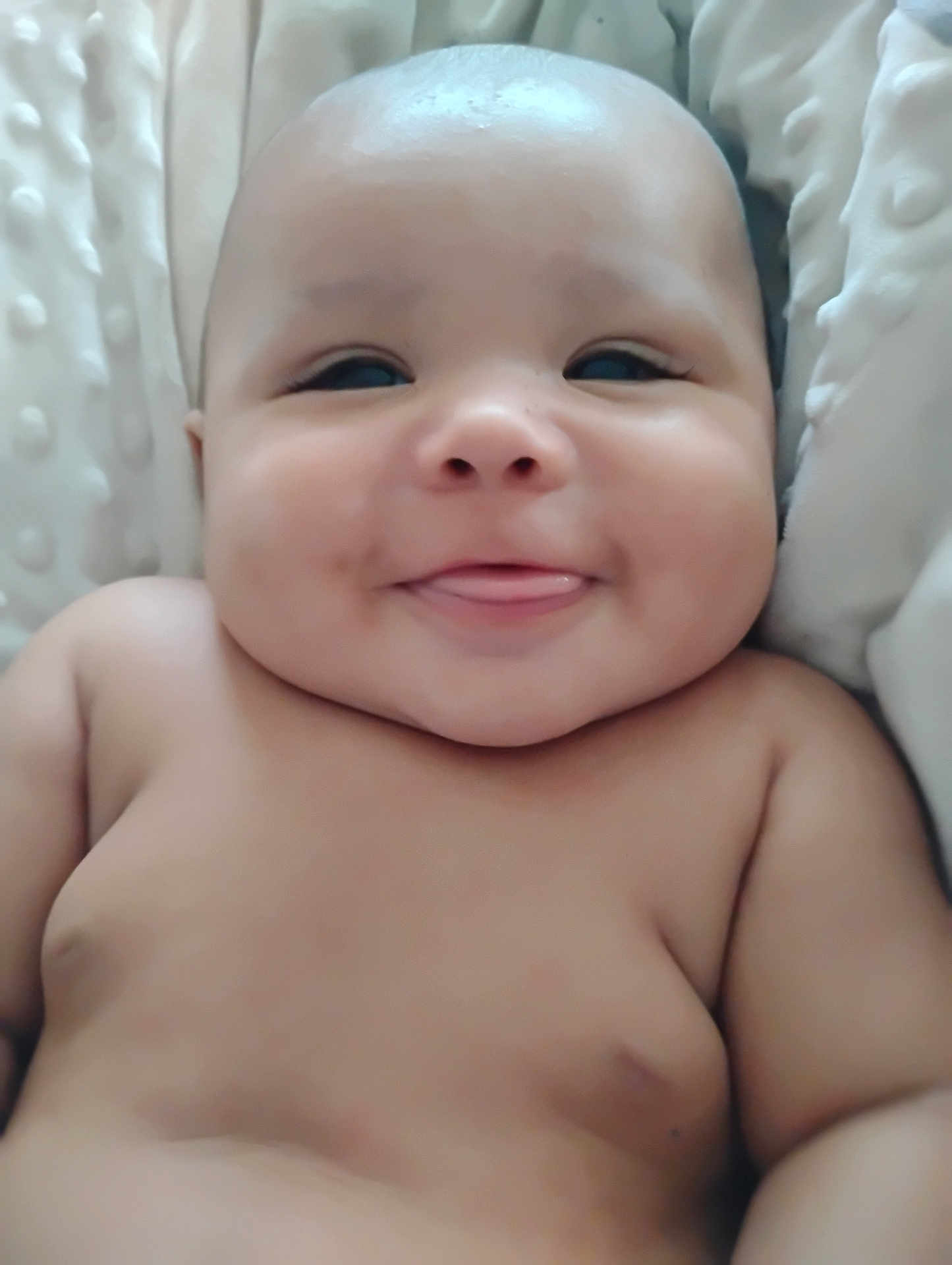 Lamont joined the competition — help win amazing prizes! baby, smiling, tongue_out, cheeks, bare_chest, infant, cute, skin, face, head, lying_down, blanket, texture, soft, young_child, happy, chubby, closeup, portrait, indoors