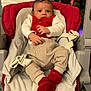 Ewen a rejoint le concours — aidez-le/la à gagner de superbes lots ! baby, baby_seat, child, christmas_tree, cushion, cute, decorations, face, festive, holiday, indoor, infant, ornaments, person, plaid_pants, red_booties, red_clothing, seatbelt, smiling, white_clothing