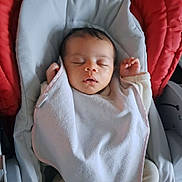 Ewen participe au concours pour gagner de l'argent avec cette photo : baby, sleeping, blanket, baby_seat, red_cushion, toy, pacifier, infant, cozy, indoors, peaceful, child, soft_fabric, cute, resting, clothing, newborn, comfort, face, hands