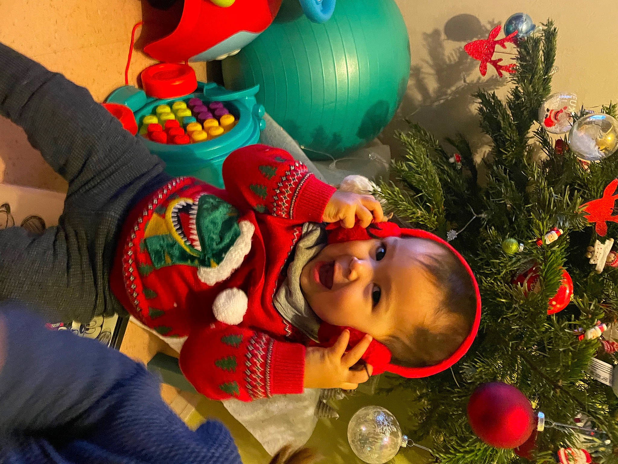 Ulysse a rejoint le concours — aidez-le/la à gagner de superbes lots ! baby, christmas, christmas_decoration, christmas_eve, christmas_ornament, christmas_tree, conifer, event, evergreen, fictional_character, fun, happy, hat, holiday, holiday_ornament, leisure, ornament, party_supply, person, red