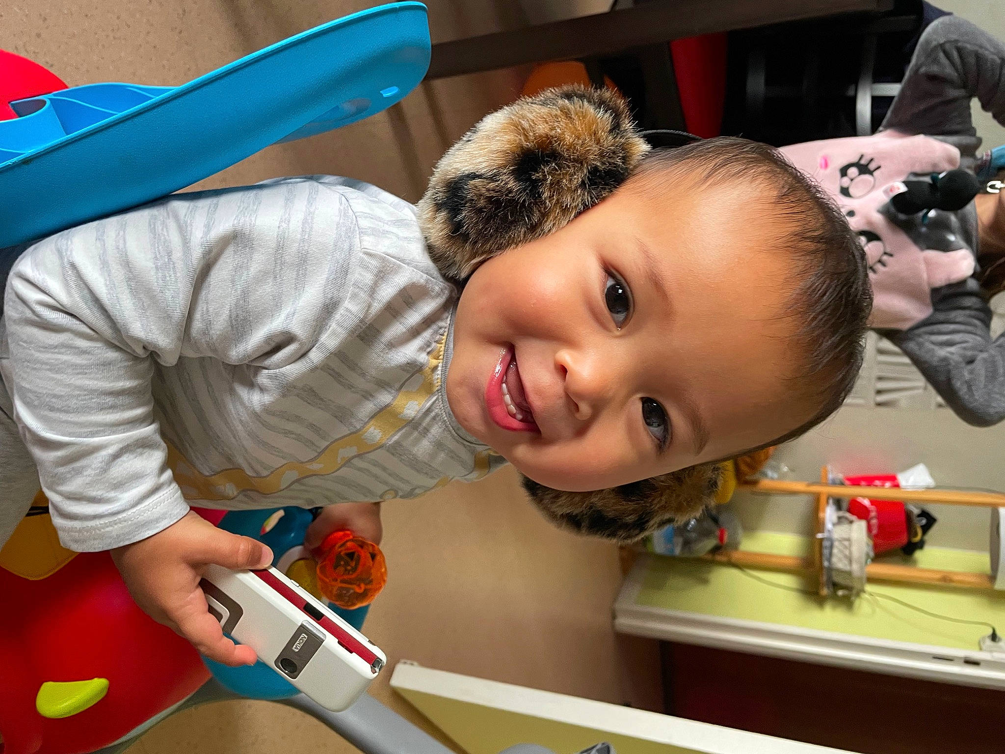 Ulysse a rejoint le concours — aidez-le/la à gagner de superbes lots ! baby, baby_playing_with_toys, camera, child, facial_expression, fun, happy, joy, leisure, person, photograph, play, product, recreation, room, single_lens_reflex_camera, smile, snapshot, t_shirt, toddler