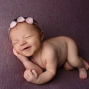 Esmée a rejoint le concours — aidez-le/la à gagner de superbes lots ! baby, newborn, sleeping, smiling, headband, flower, purple_blanket, skin, infant, cute, peaceful, lying_down, hand_near_face, portrait, soft_texture, closed_eyes, adorable, child, resting, small