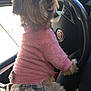 Praline participe au concours pour gagner de l'argent avec cette photo : car_interior, casual, clothing, companion, cozy, cute, daylight, dog, domestic_animal, fur, happy, human_hand, lap, pet, pink_sweater, plaid_skirt, seated, small_dog, steering_wheel, window