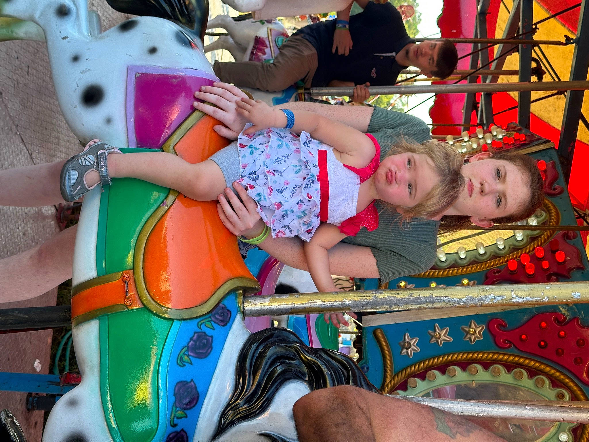 Roselynn joined the competition — help win amazing prizes! amusement_park, amusement_ride, carousel, child, entertainment, event, fun, head, human_body, leisure, nonbuilding_structure, pattern, person, pink, public_event, recreation, sandal, thigh, toddler, vacation